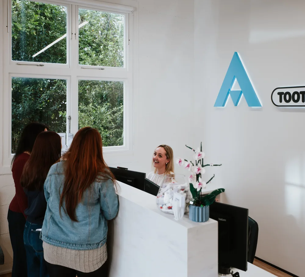 A receptionist helping patients at Auckland City Orthodontics