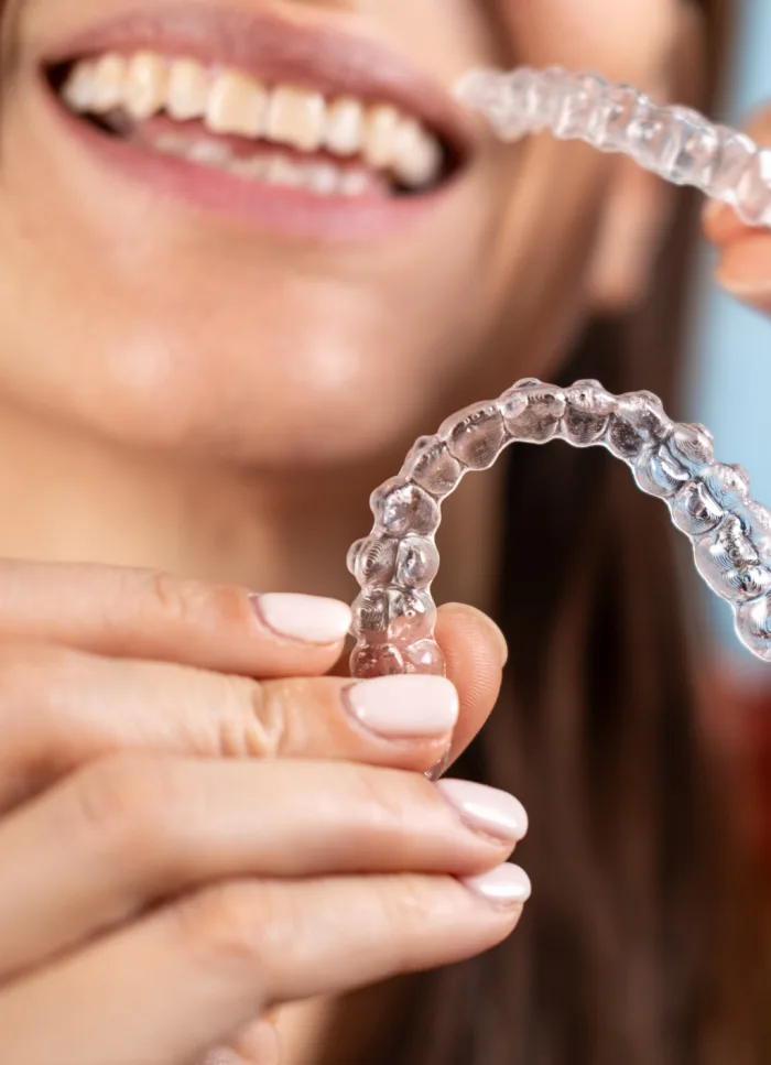 An adult holding a clear aligner