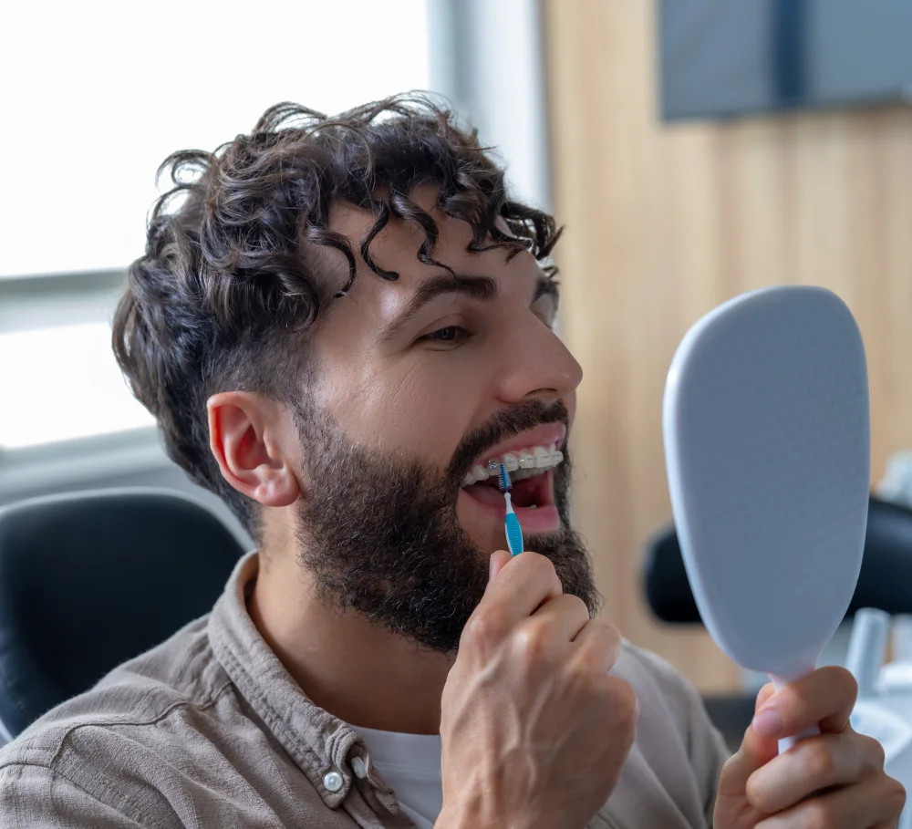 An adult checking their smile in a mirror