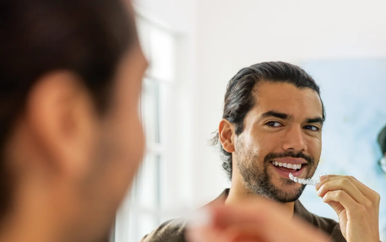 An adult putting in an Invisalign® clear aligner
