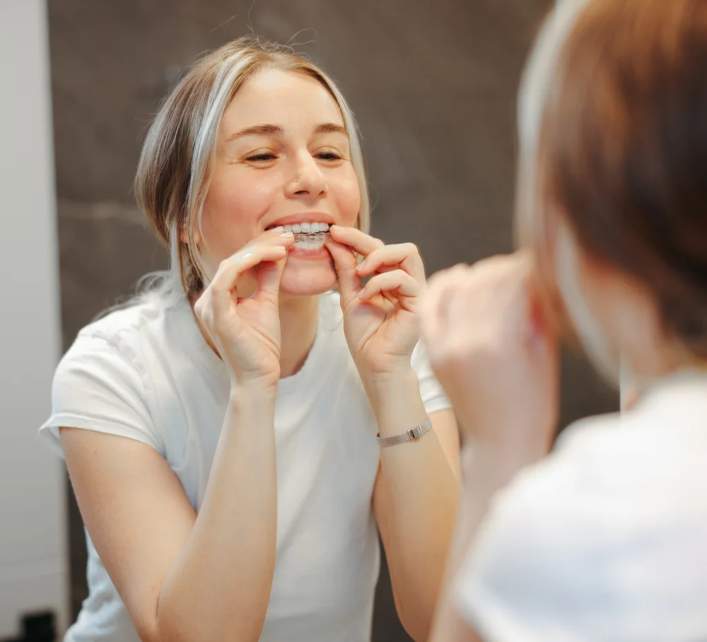 A woman putting in a clear aligner