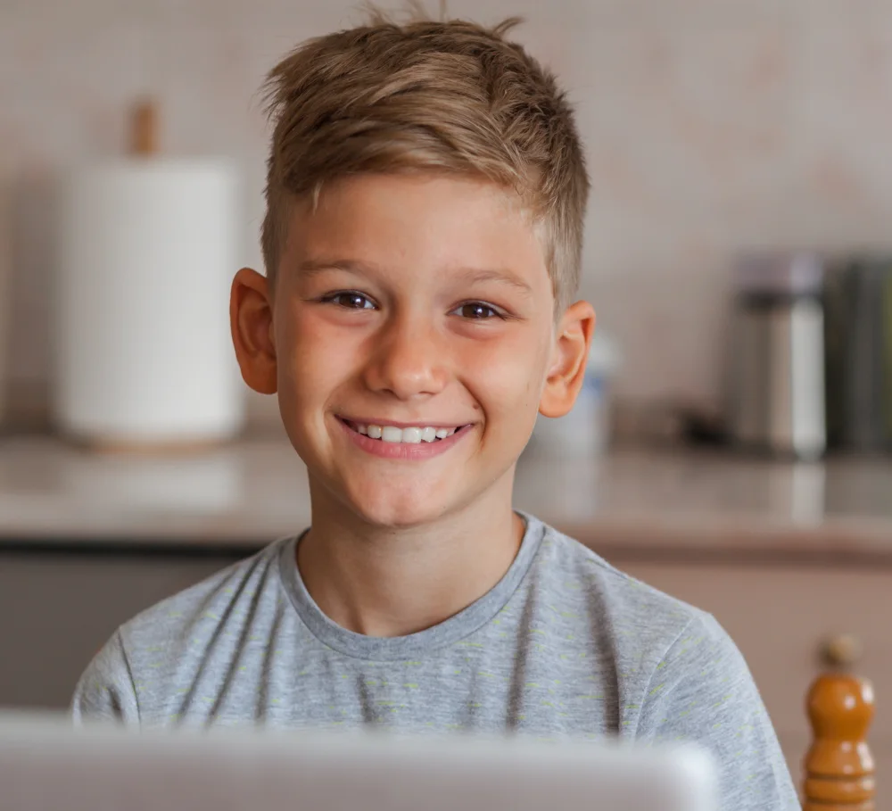 A smiling boy at a laptop
