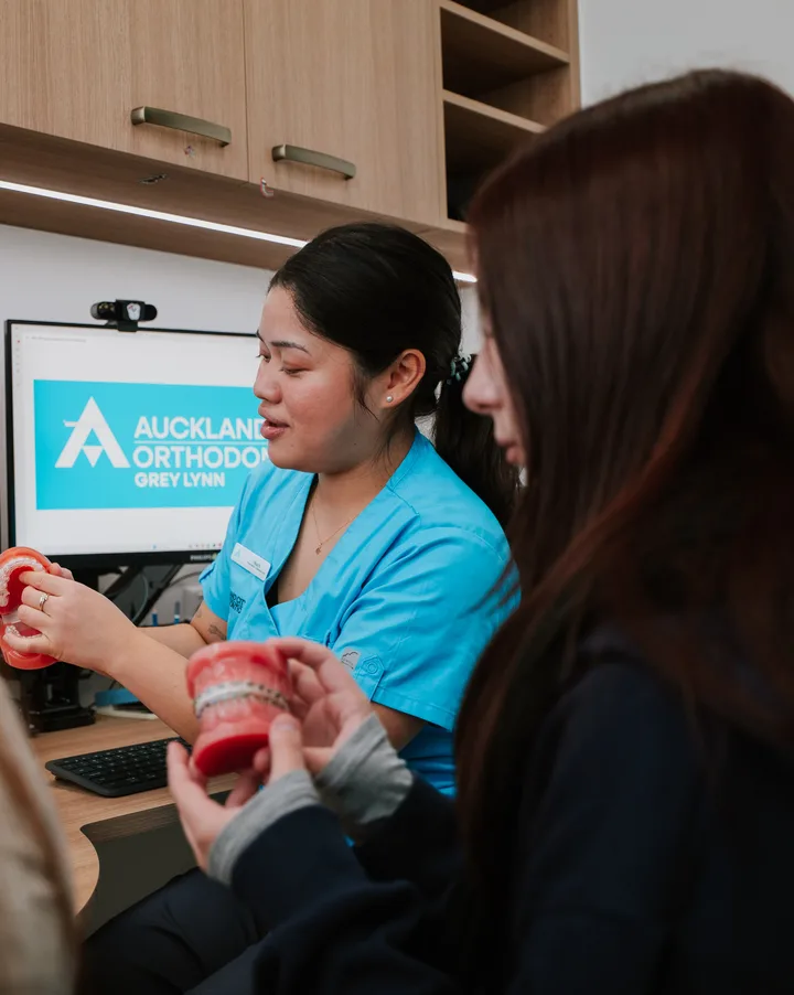 A treatment coordinator showing braces models to a patient