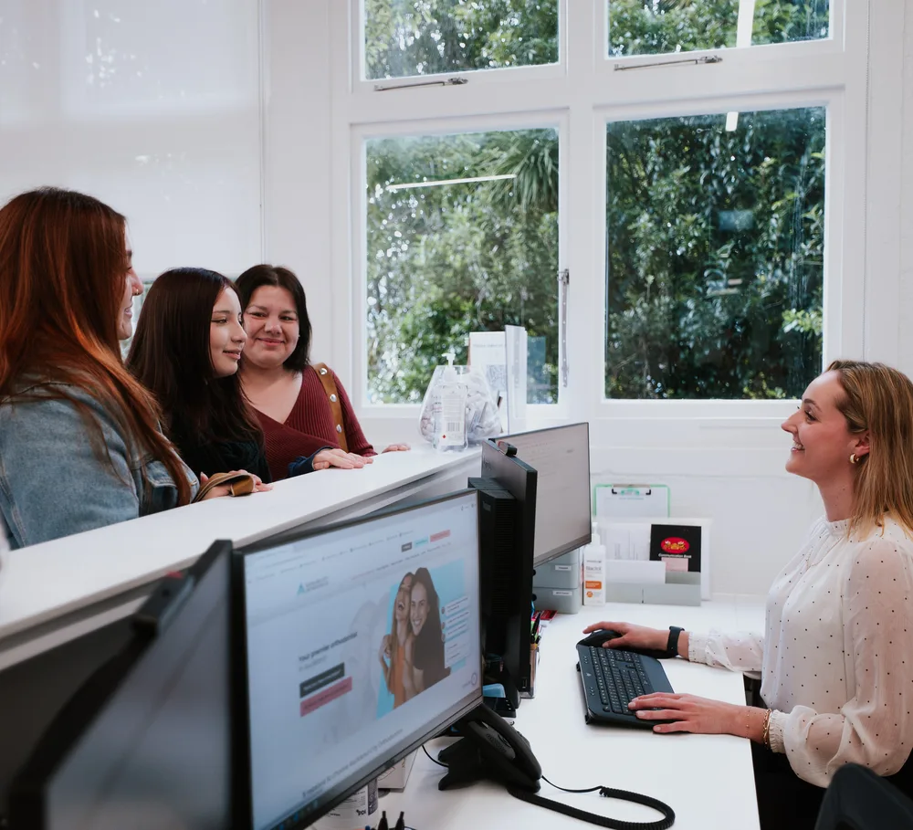 A receptionist helping patients at Auckland City Orthodontics