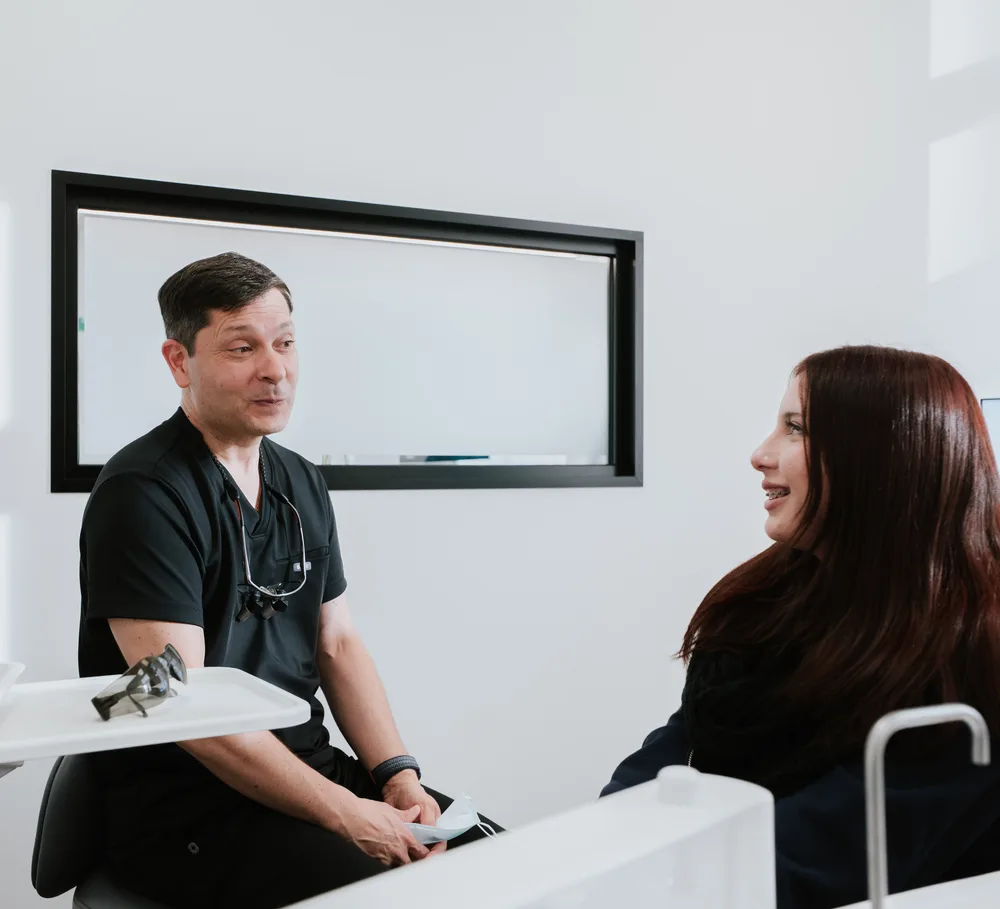 A Specialist Orthodontist chatting with a teenage patient
