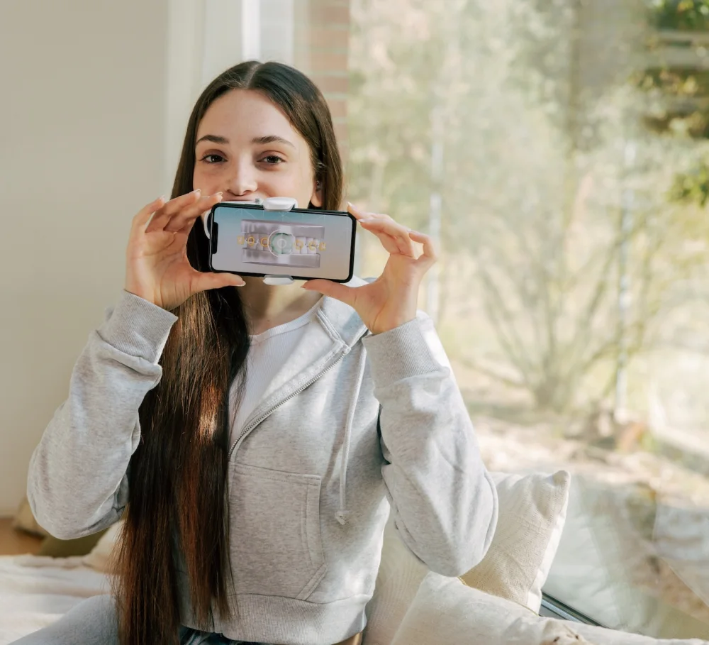 A patient taking a Dental Monitoring scan with a smartphone